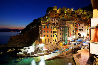 Canal amidst buildings in city at night