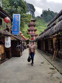 Full length of woman walking against building