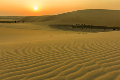 Scenic view of desert against sky during sunset