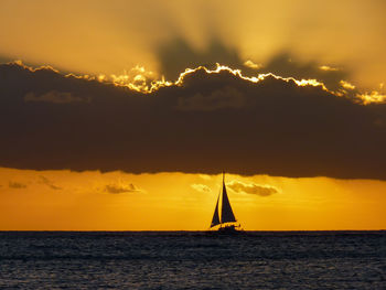 Silhouette of boats in sea during sunset