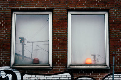Windows amidst red brick wall