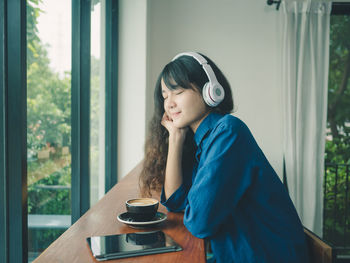 Woman holding coffee cup sitting on table