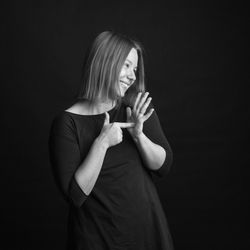 Young woman wearing mask against black background