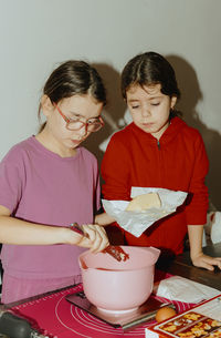 Two beautiful caucasian girls are baking cookies.