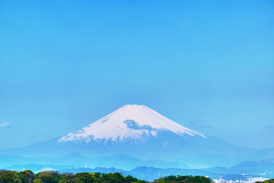 Scenic view of snowcapped mountains against blue sky