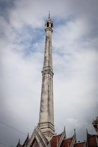 Low angle view of tower against cloudy sky