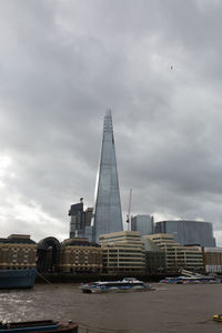 Buildings in city against cloudy sky