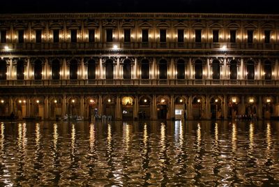 Reflection of illuminated building in water at night