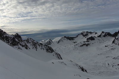 Scenic view of snow covered mountains against sky