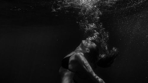 Side view of young woman swimming in sea