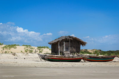 Boat moored on beach against sky