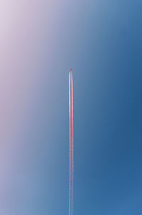 Low angle view of airplane flying against blue sky