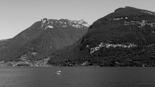 Scenic view of mountain by sea against sky