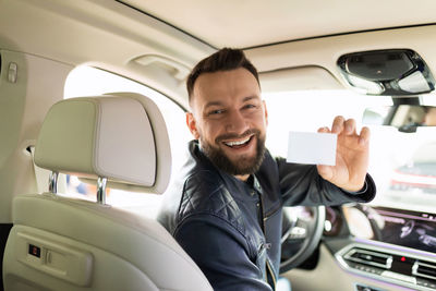 Portrait of smiling mam sitting in car