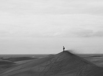 Man standing on desert against sky