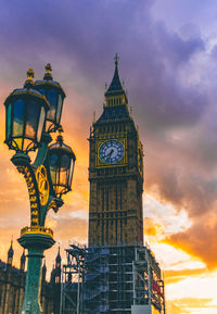 Low angle view of clock tower against cloudy sky