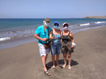 Rear view of people standing on beach