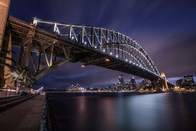 View of bridge over river at night