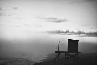 Lifeguard hut on sea against sky at dusk