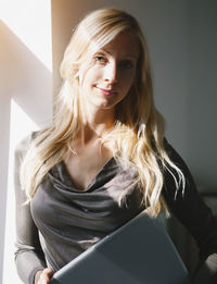 Portrait of young woman using mobile phone at home