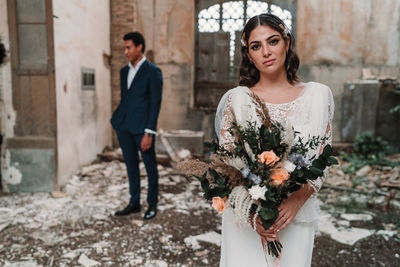 Full length of young woman standing against wall