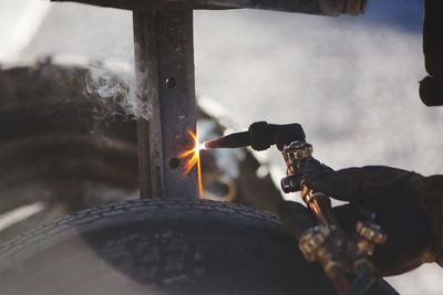 Close-up of person working with flaming torch on table