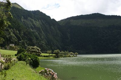 Scenic view of lake by mountains against sky