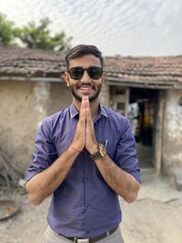 Portrait of young man wearing sunglasses standing outdoors