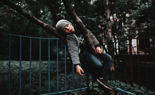 Full length of boy sleeping on the tree