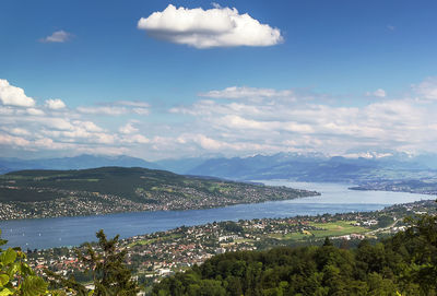 Scenic view of town by sea against sky