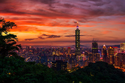 Illuminated buildings against sky during sunset