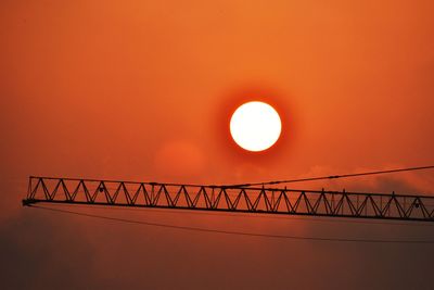 Low angle view of bridge against orange sky