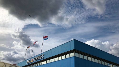 Low angle view of flag on building against sky