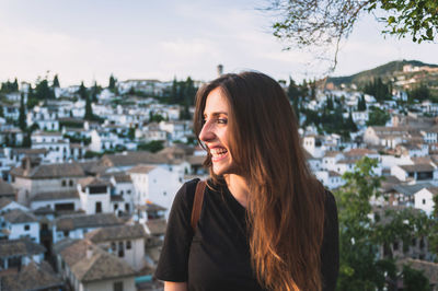 Portrait of young woman against granada cityscape