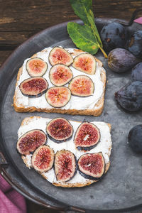 Bruschetta with soft ricotta with ripe figs served on a tray. vertical picture