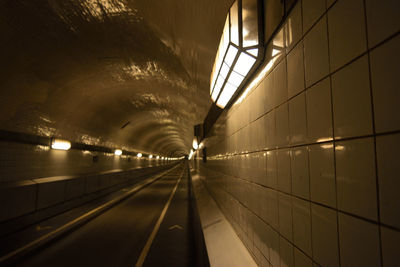 Illuminated underground walkway at night