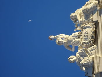 Low angle view of statue against blue sky