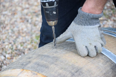 Cropped image of worker working on wood with tools