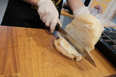 Female hands spreading cheese on a slice of bread
