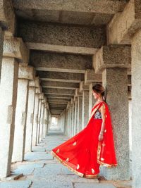 Woman in sari leaning against column