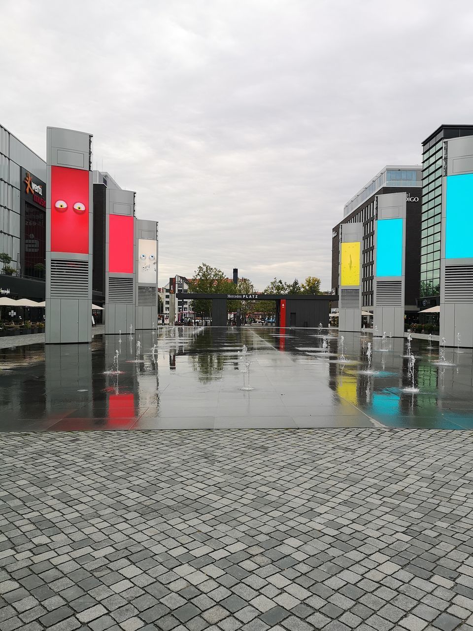 WET ROAD BY BUILDING AGAINST SKY