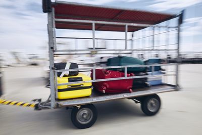 Traveling by airplane. suitcases in luggage trailer in blurred motion at airport.