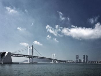 View of suspension bridge against cloudy sky