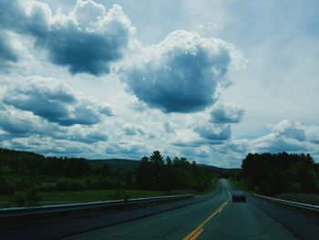 Empty road against cloudy sky