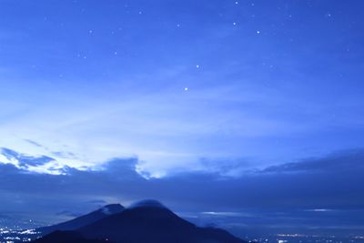 Scenic view of mountains against blue sky at night