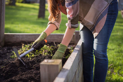 Midsection of woman digging soil