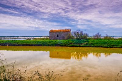 Reflection of building in lake against sky