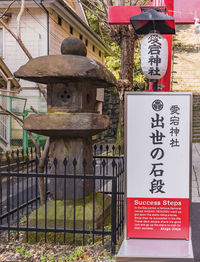 Information sign on fence against building