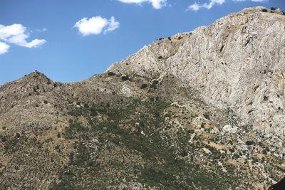 Low angle view of rocky mountains against sky