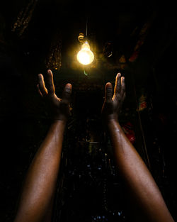 Close-up of hand holding illuminated electric lamp